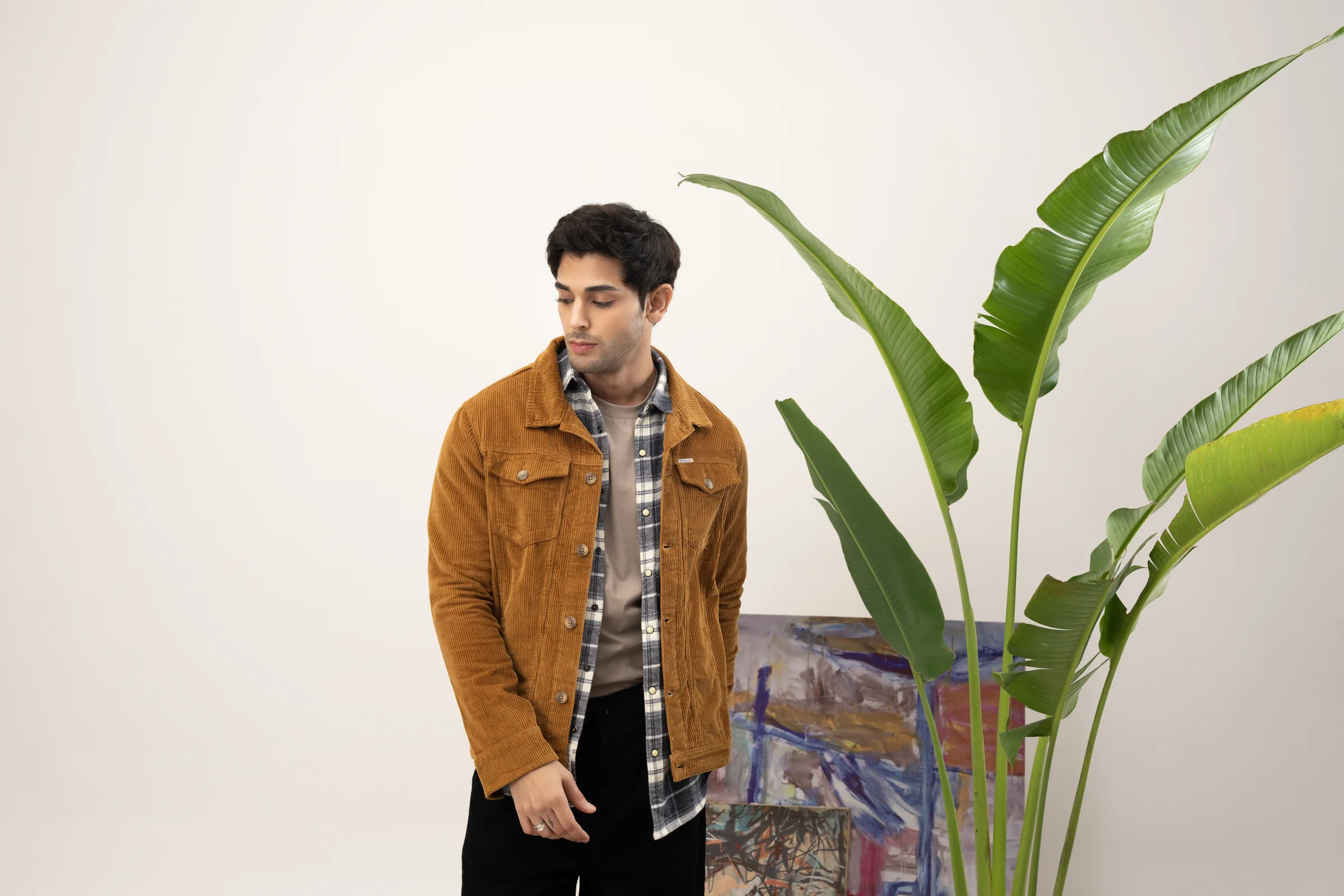 Model wearing a tobacco corduroy jacket with layered winter checks